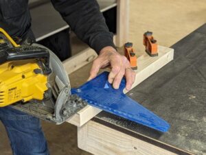 Cursist leert om met een hand cirkelzaag hout te zagen.