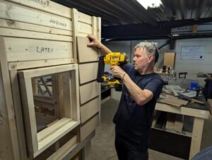 Cursist maakt een houten wand tijdens cursus houtskeletbouw.