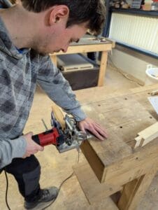 Een cursist maakt tijdens de cursus een deuvelverbinding.