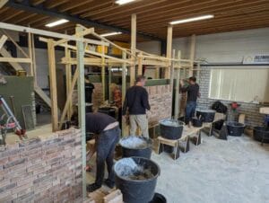 Een groep cursisten aan het werk tijdens de cursus metselen.