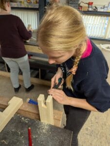 een cursist maakt hout een verbinding tijdens de basis cursus timmeren