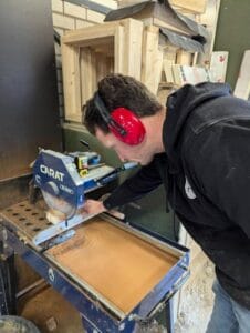 Een cursist gebruikt de steenzaag tijden de metsel cursus.